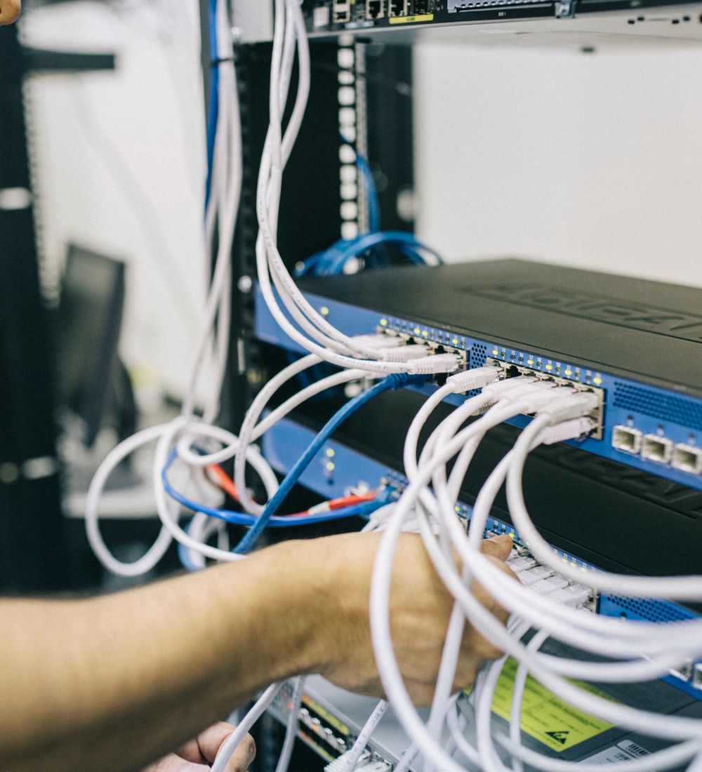 Especialista conectando equipos dentro de un rack de red